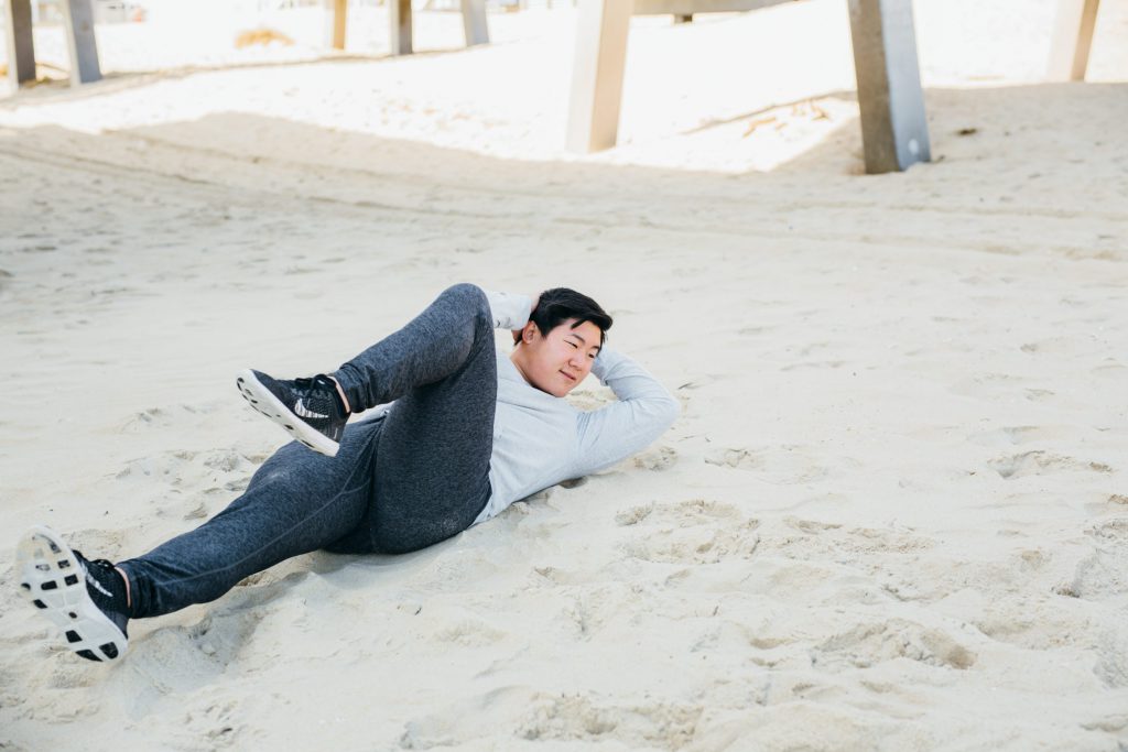 A man is doing ab exercises on the beach