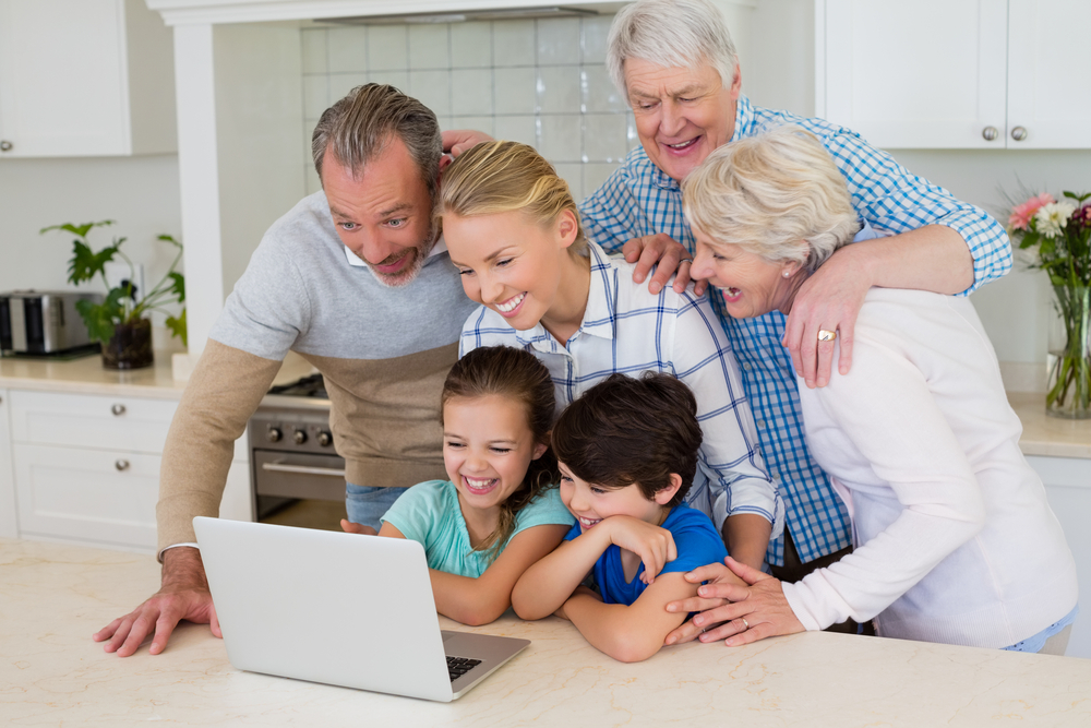 Happy family using laptop in kitchen at home