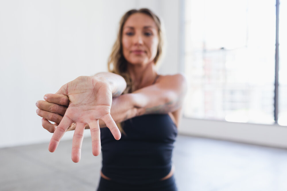 Woman performing wrist stretch.