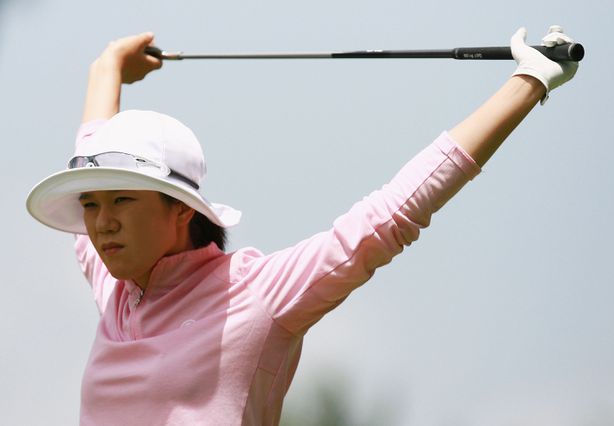 Woman golfer using her club to stretch overhead