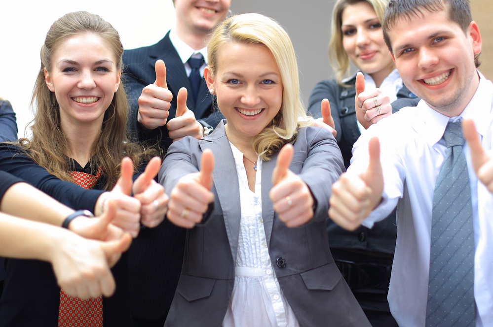 A group of business people giving a thumbs up
