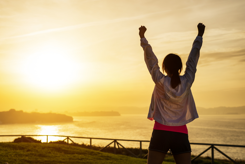 Successful sporty woman with arms up