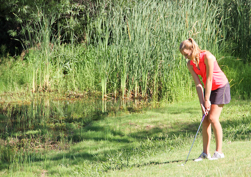 A woman golfer out of bounds.