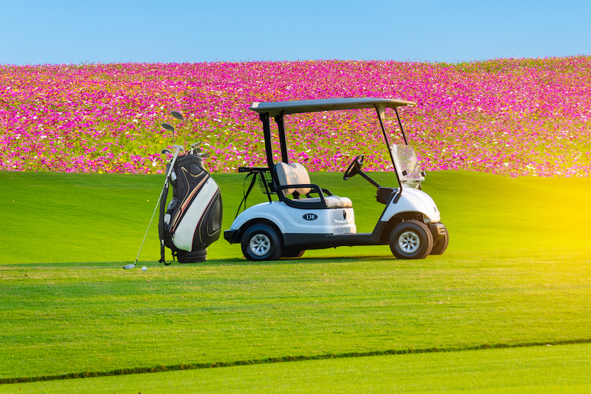 Spring flowers on a golf course behind a golf cart